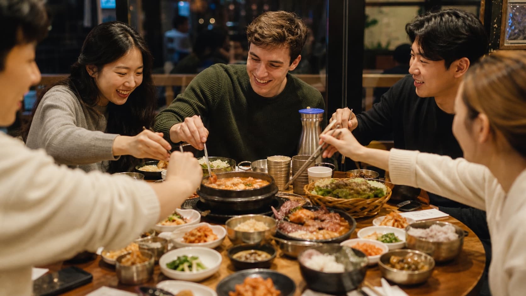 Friends sharing Korean food at a restaurant table