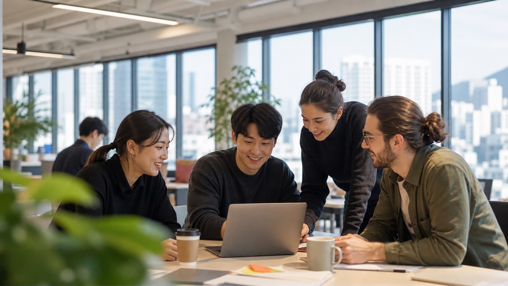 Korean and international coworkers reviewing a laptop in Seoul